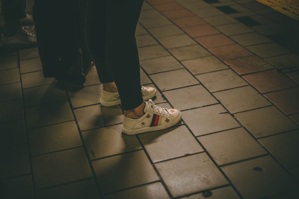 Casual sneakers on a subway platform capturing urban street style.