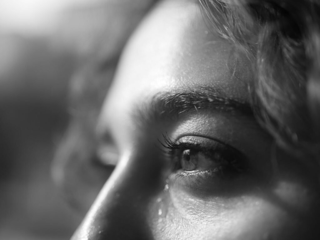 Black and white close-up of a human eye expressing emotion. Captures the essence of feelings.