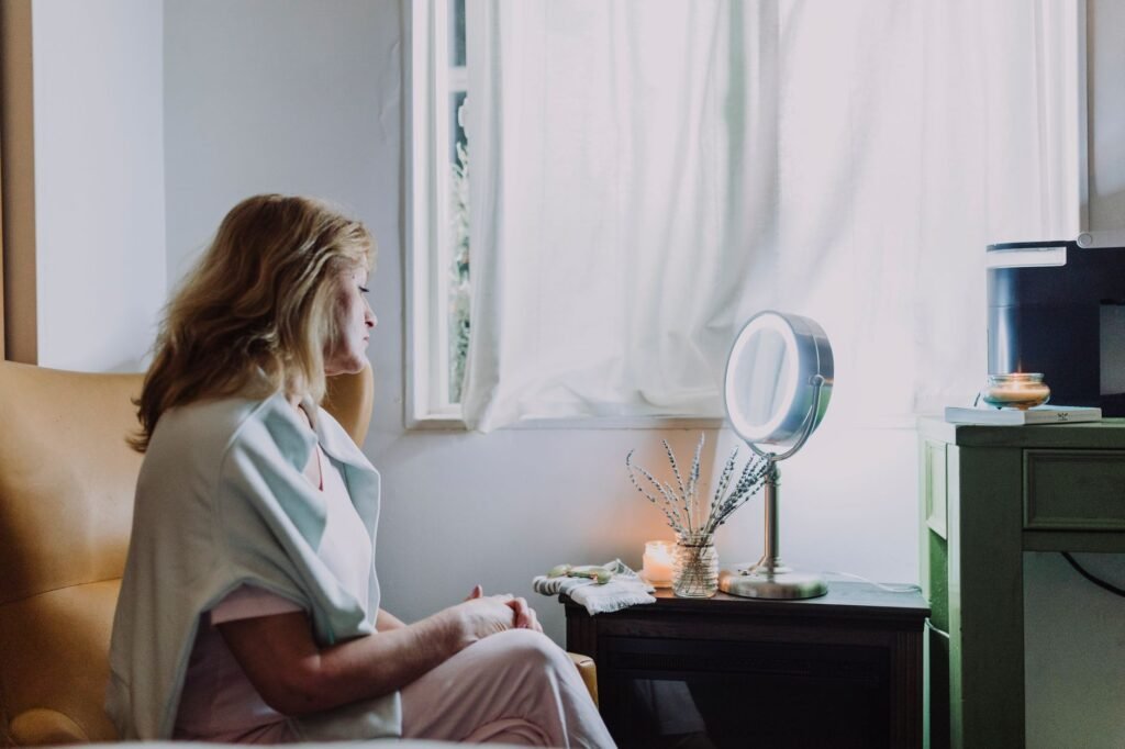 A serene moment captured as a woman relaxes in a cozy interior setting by the window.
